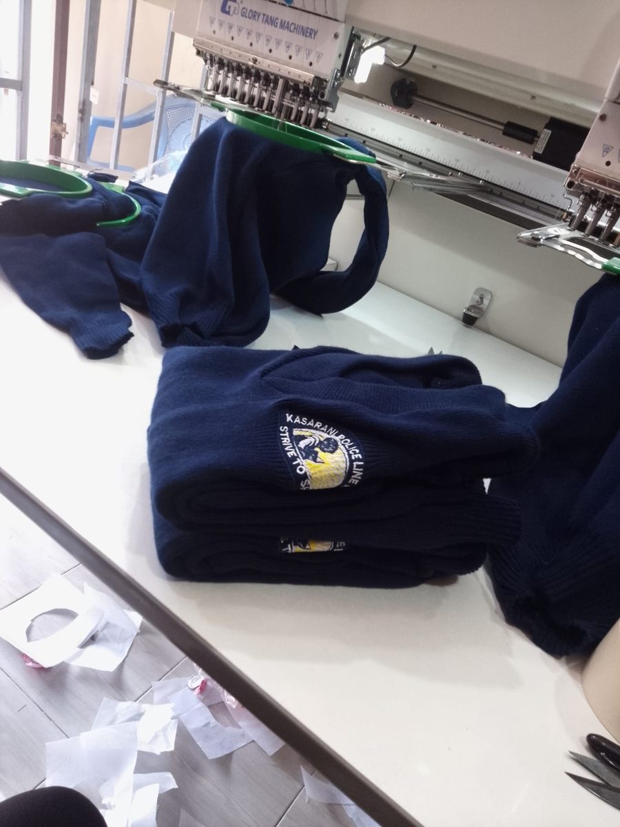 Multi-head embroidery machine stitching a school crest on navy sweaters in our Nairobi workshop